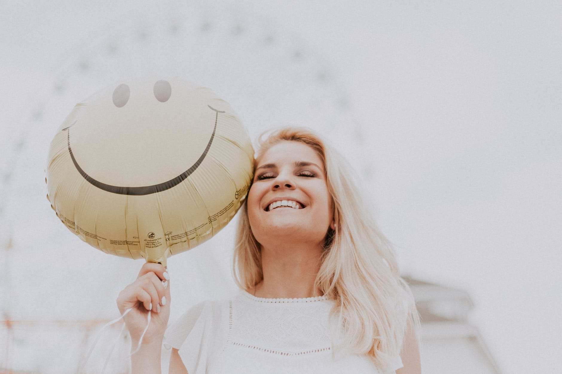 une femme souriante avec un ballon smiley