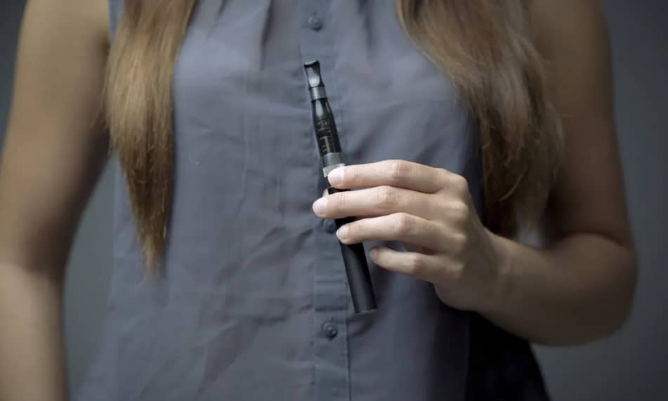Femme qui tient une cigarette électronique