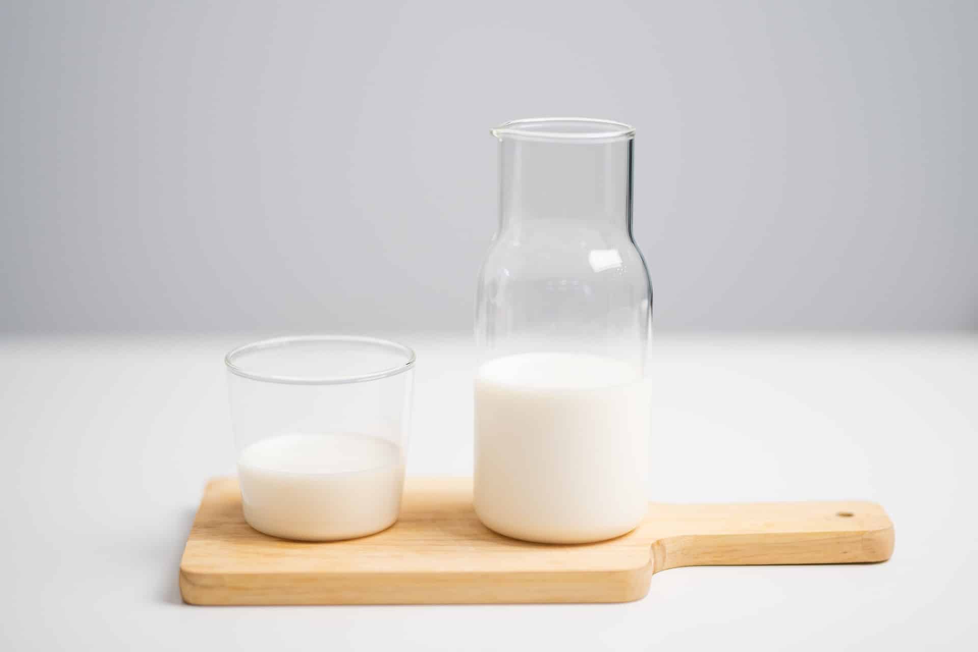 verre et pichet de lait sans lactose sur planche en bois