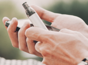 mains tiennent portable et cigarette électronique blanche