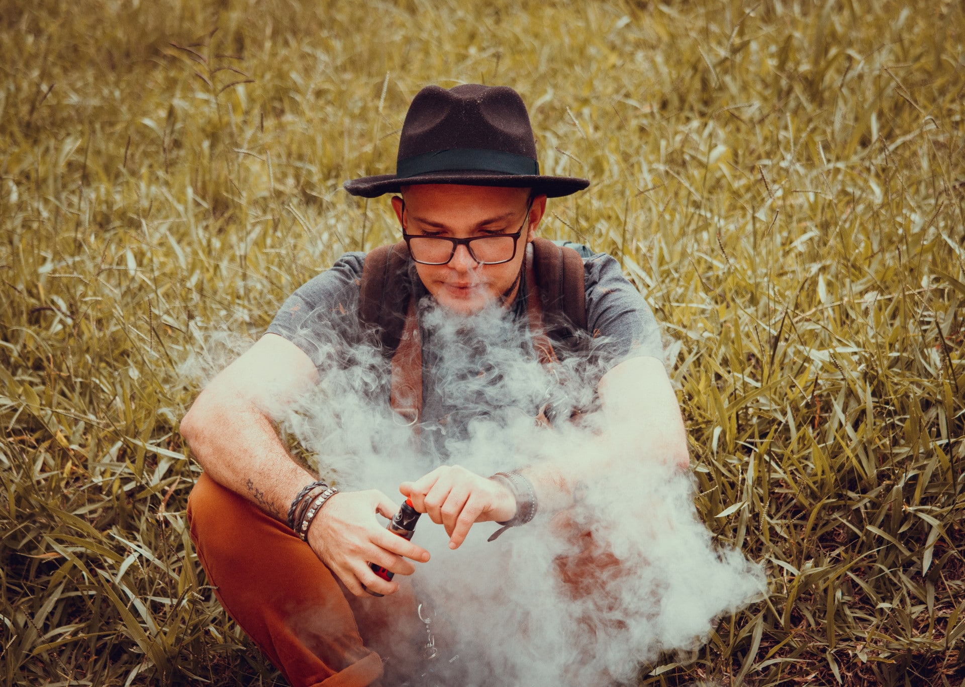 vapotage adolescent : adolescent tenant une cigarette électronique discutant avec un parent